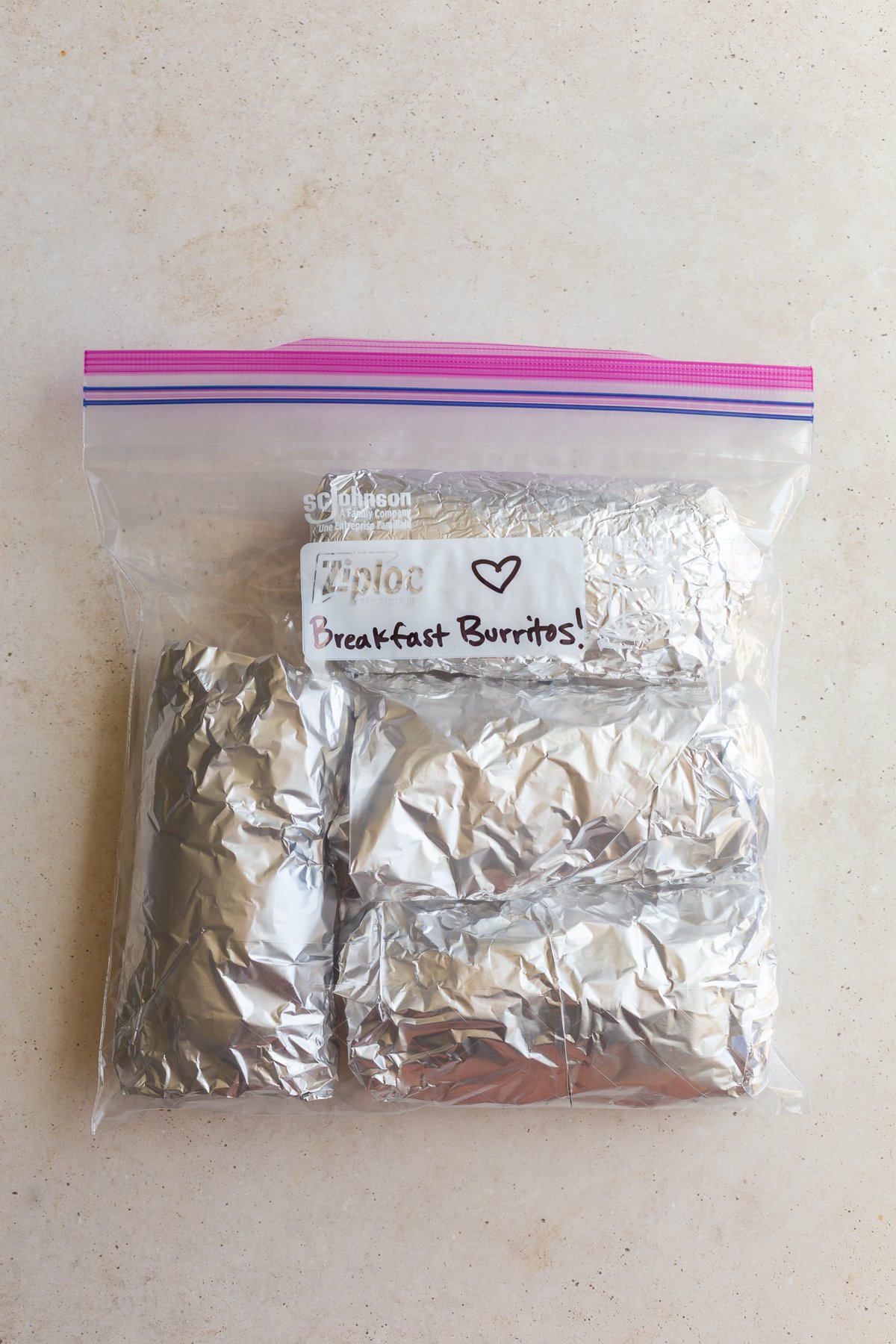 freezer breakfast burritos wrapped in foil and placed in a gallon baggie labeled "Breakfast burritos!"