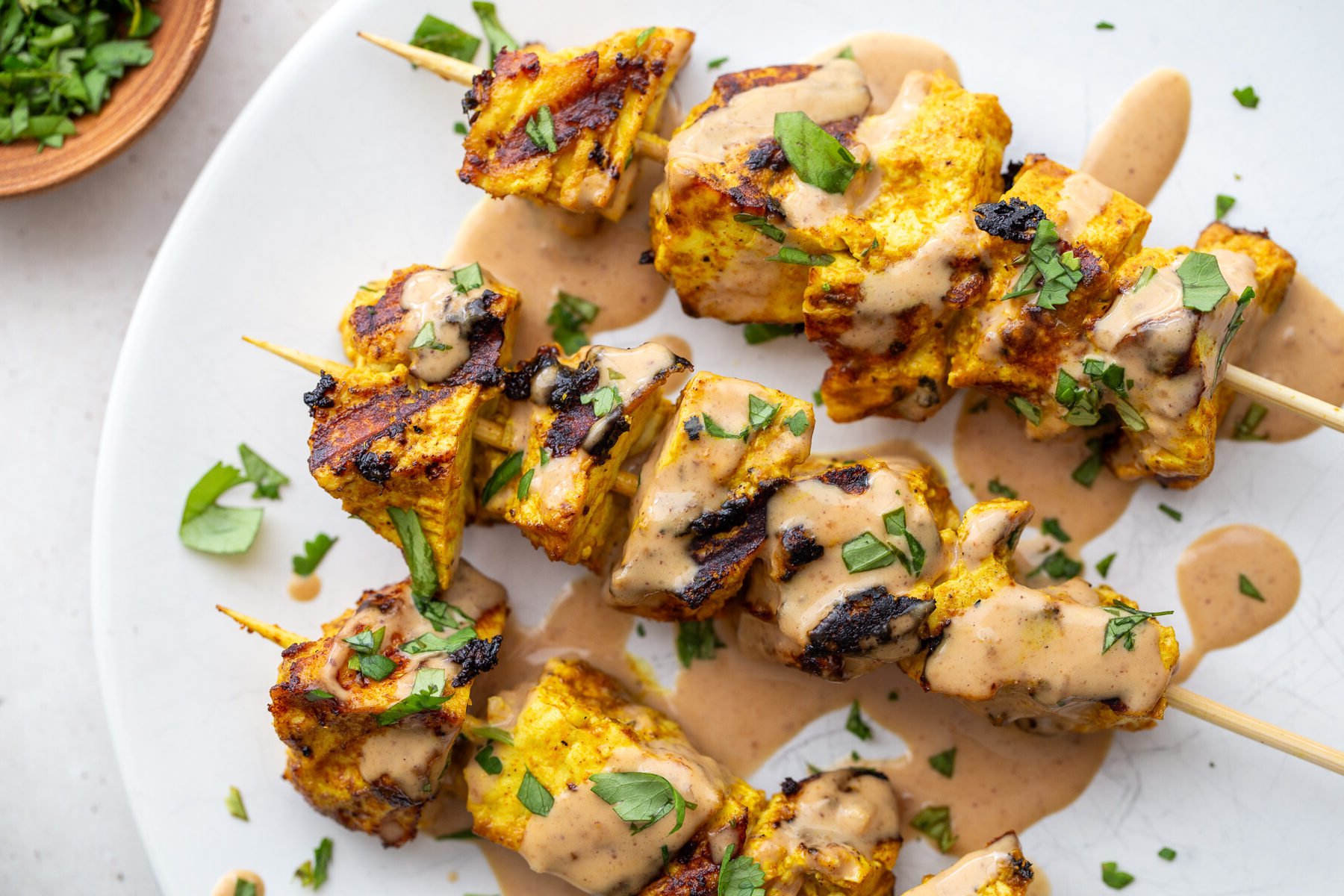 Tofu satay on a white plate.