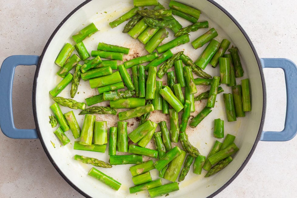 asparagus pieces sauteeing in a large skillet