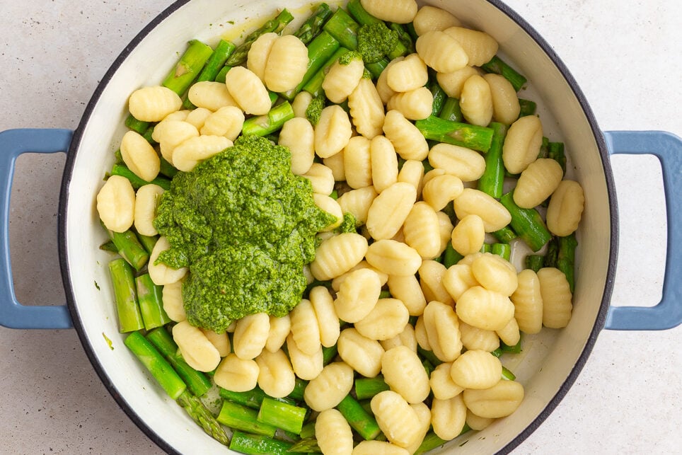 how to make pesto gnocchi: add pesto and cooked gnocchi to the pan with the sauteed asparagus
