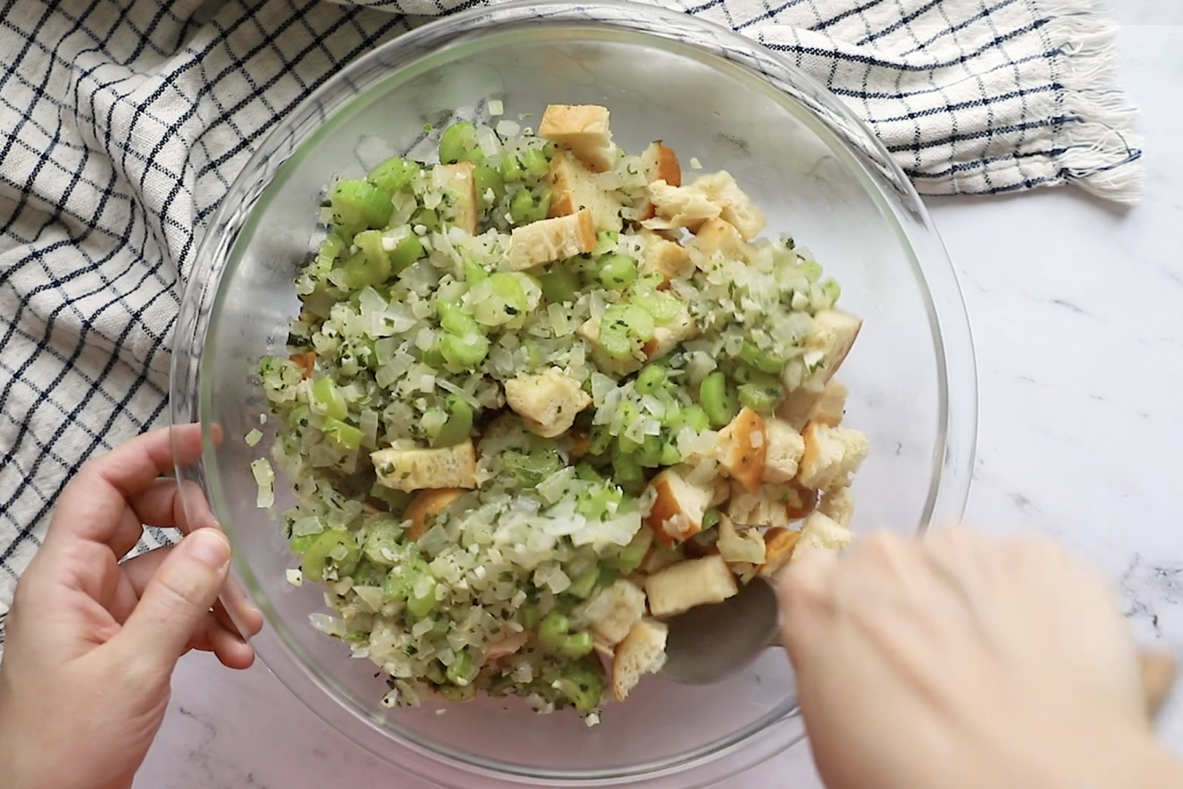 sauteed onion and celery in a large bowl with toasteed bread to make vegan stuffing