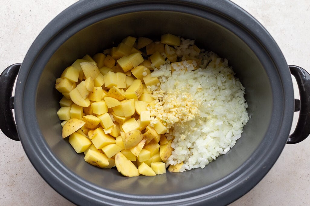 potatoes, onion and garlic in a crockpot to make slow cooke potato soup