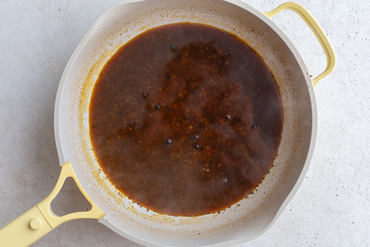 broth in a large skiller for peppercorn sauce