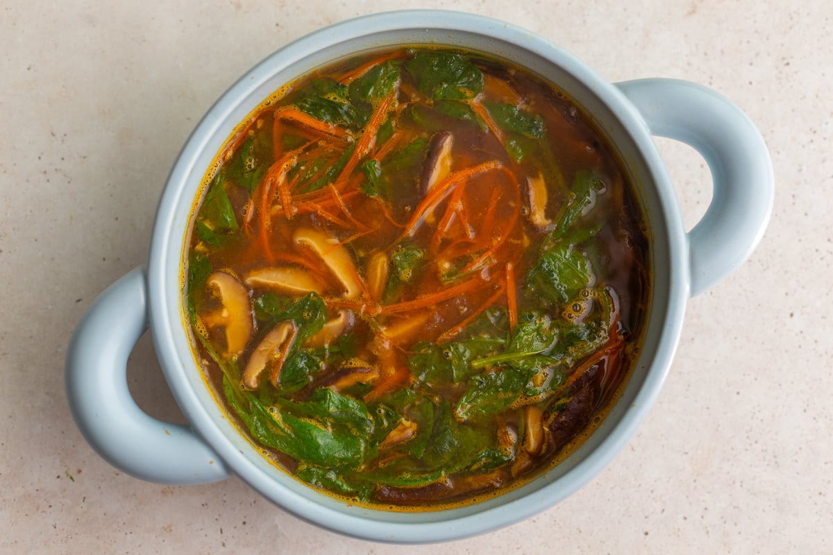 how to make homemade ramen: step 3 add in the veggies to the broth and mushrooms