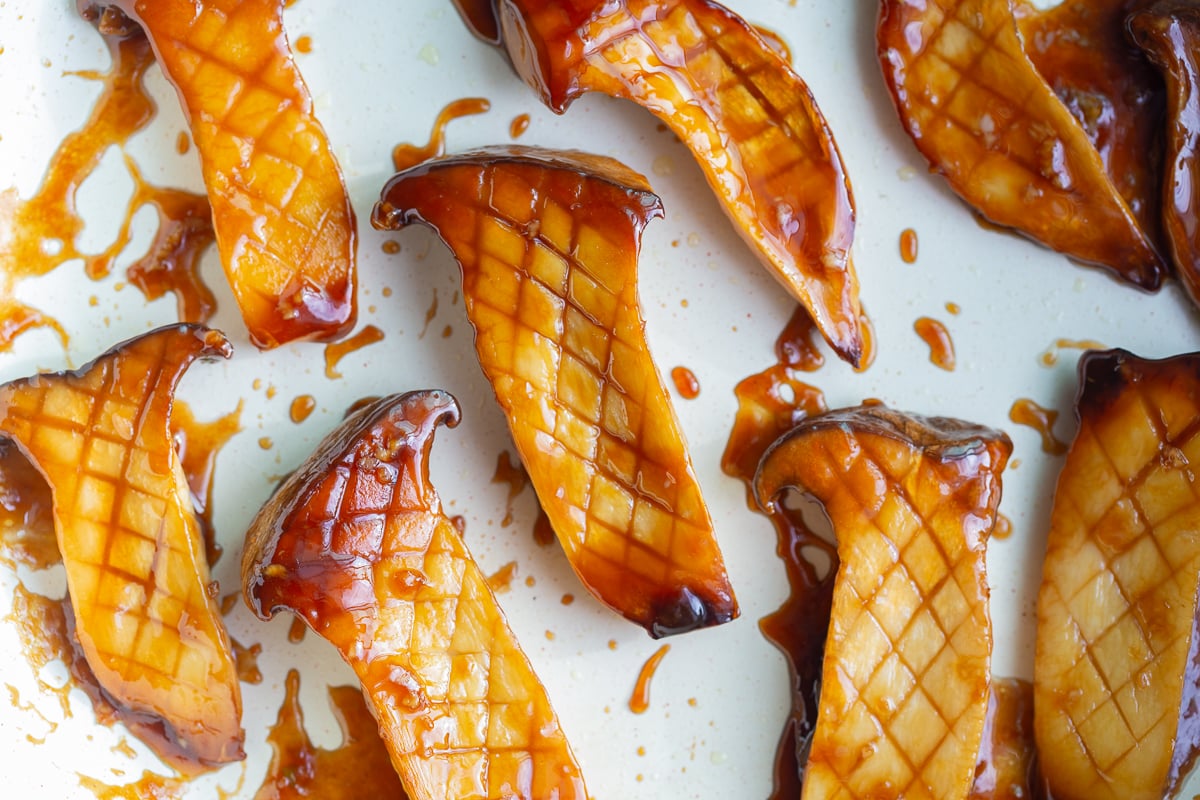 king oyster mushrooms in a skillet cooked with sticky teriyaki sauce