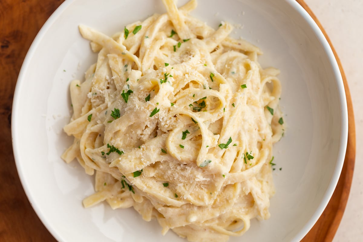 large bowl of fettuccini alfredo homemade topped with fresh parsley