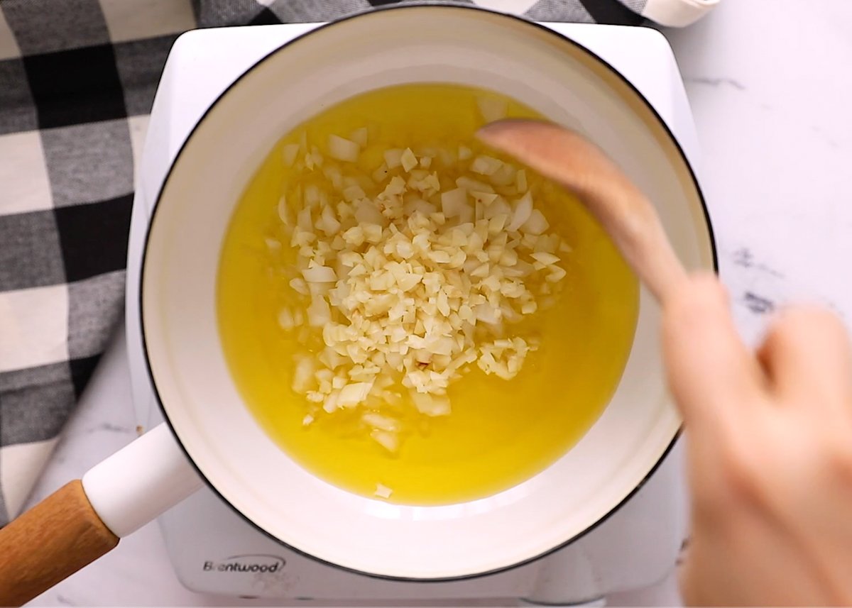 step 1 in making vegan gravy - sauteeing onion and garlic in a pot of olive oil