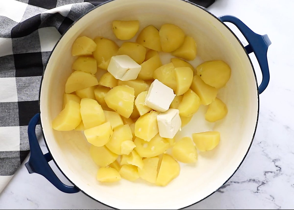 cooked potatoes and butter in a pot to make vegan mashed potatoes