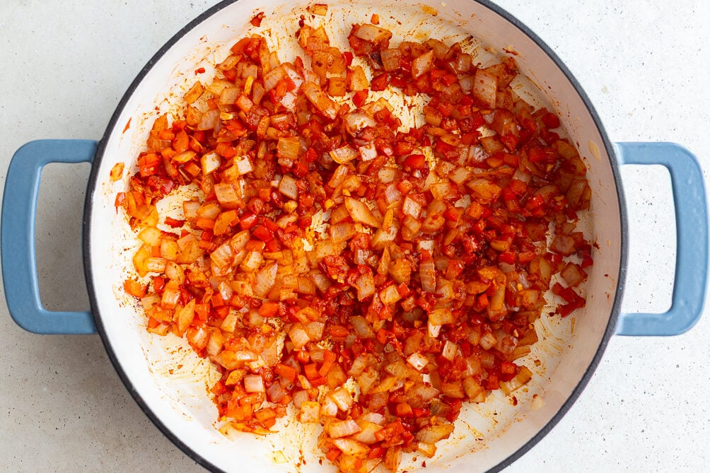 how to make vegan sloppy joes: sauteed veggies in a pan with tomato paste mixed in