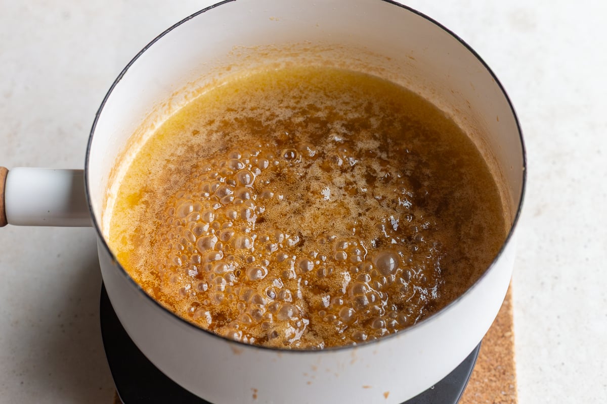 how to make christmas crack: make the toffee by simmering together the butter and brown sugar