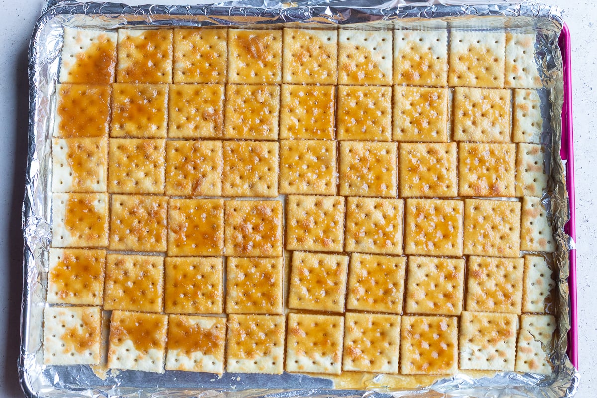 how to make christmas crack: picture of saltine toffee after being baked in the over