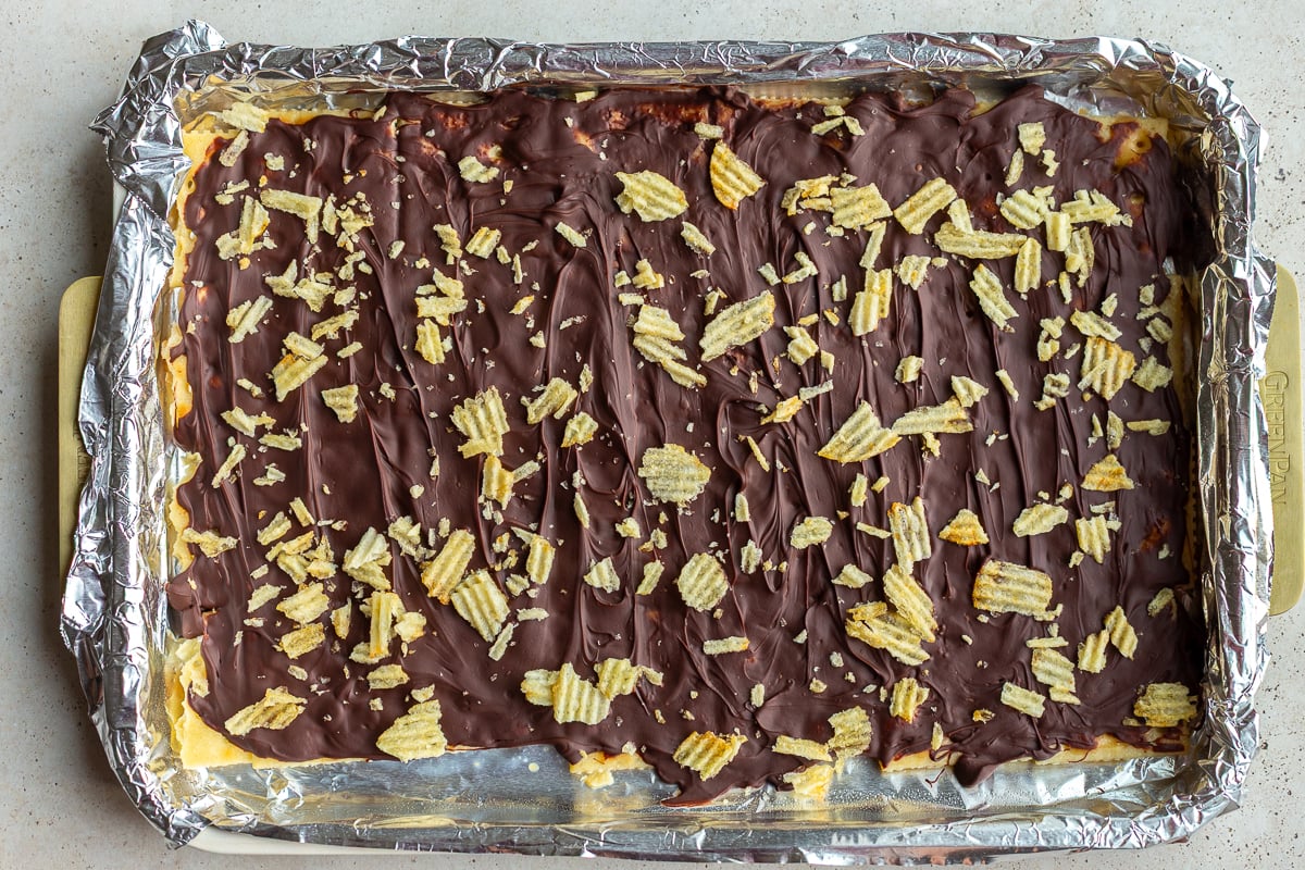 christmas crack candy on a baking tray and topped with crushed potato chips