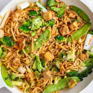 peanut tofu noodles in a skillet with veggies and tofu chunks