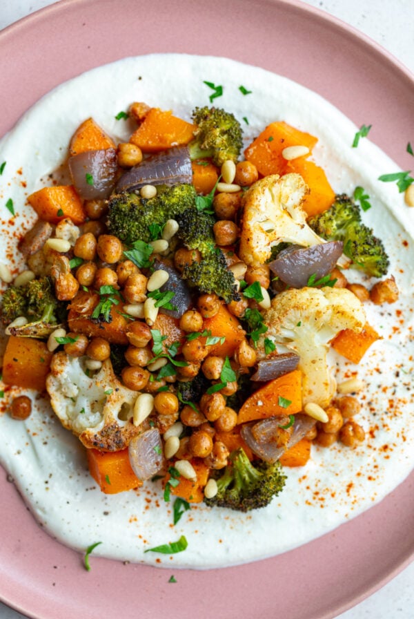 pink plate with whipped feta and roasted veggies on it