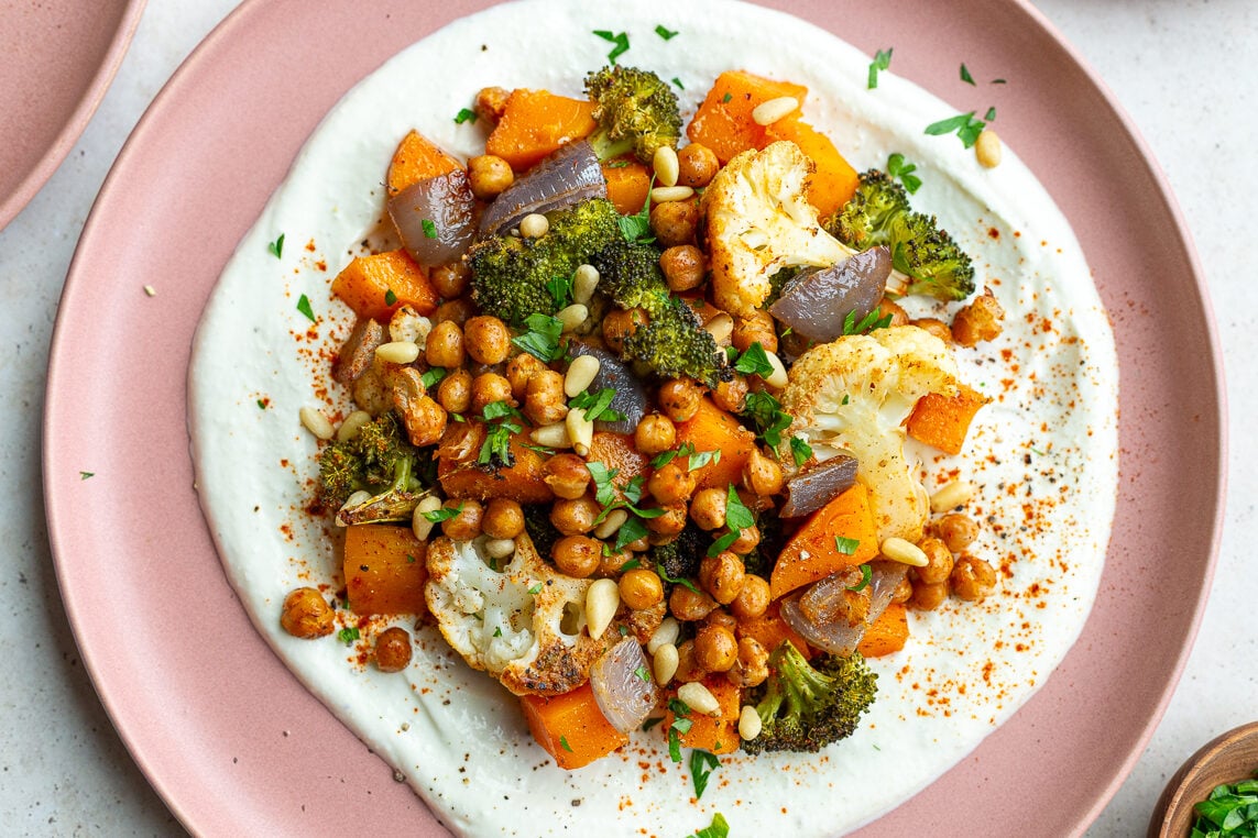 pink plate with whipped feta and roasted veggies on it