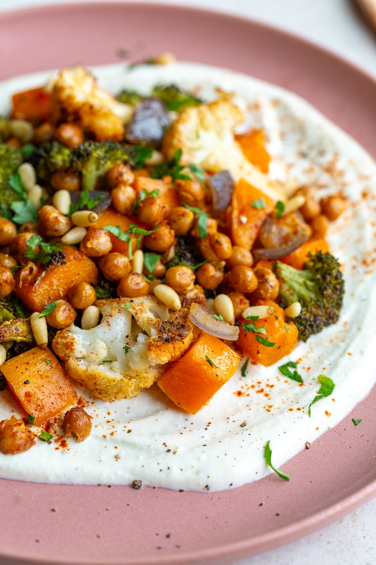 pink plate with whipped feta and roasted veggies on it