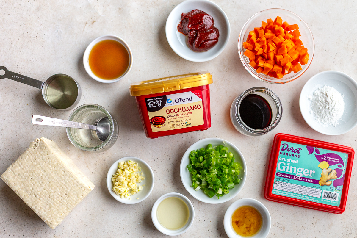 ingredients needed to make gochujang tofu including gochujang sauce, garlic, ginger, tofu, green onion and oil