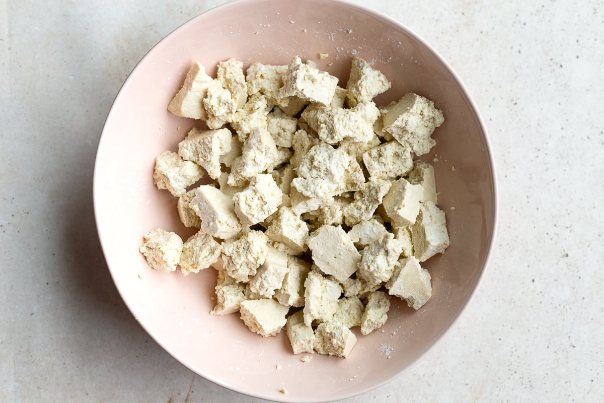 tofu chunks in a large pale pink bowl