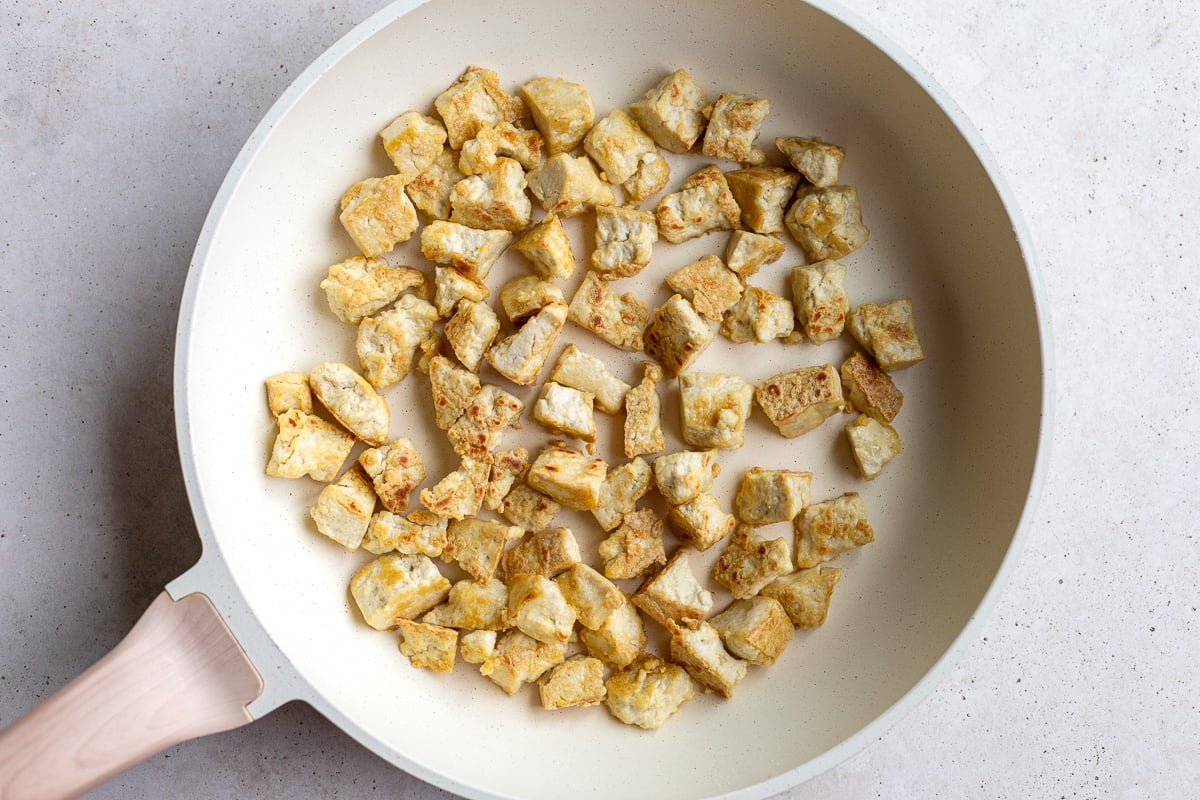 crispy tofu in a large white skillet