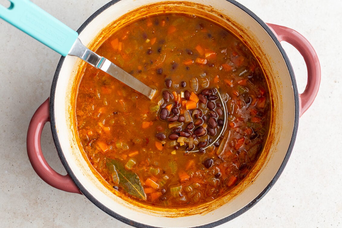 how to make black bean soup step 2 is to add in beans, broth, spices, and bay leaf and let simmer