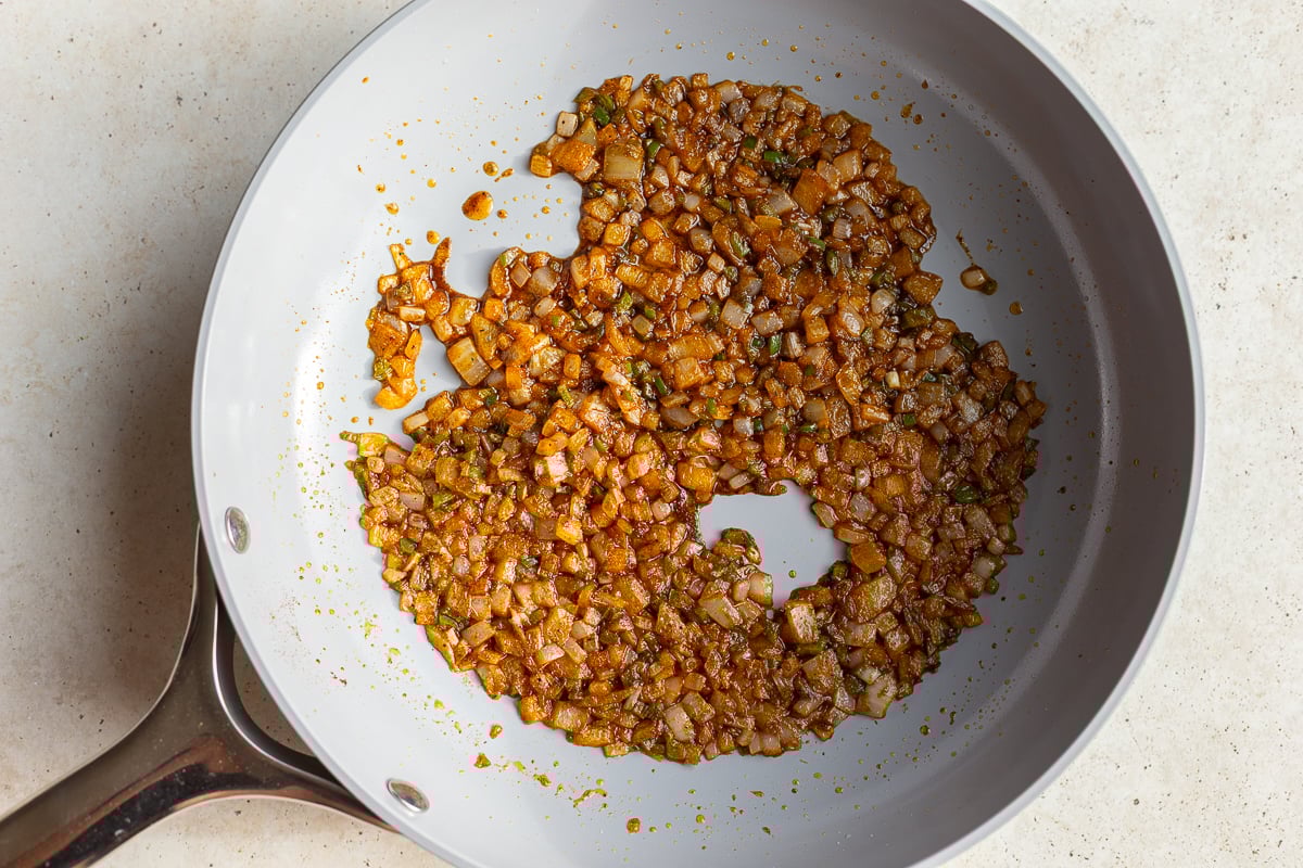 how to make refried beans: start by sauteing onion in spices and oil