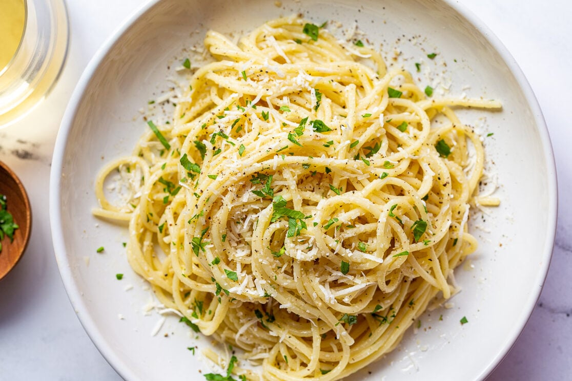 white wine pasta in a salad bowl topped with fresh herbs
