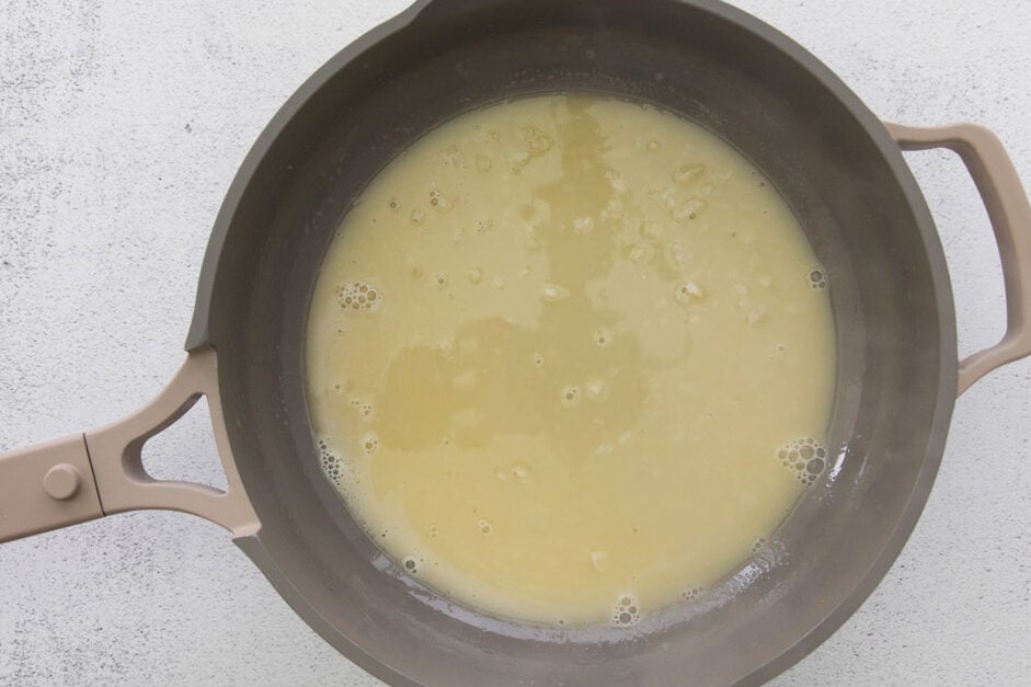 making a white wine sauce in a large skillet