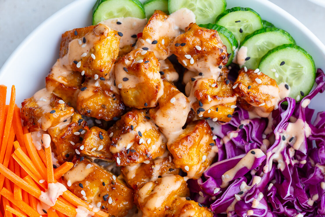 bang bang tofu bowls with rice, cucumber, red cabbage, and carrot sticks