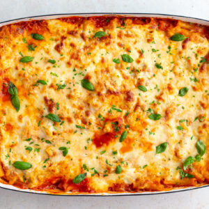 classic baked ziti without meat in a large casserole dish and topped with fresh basil