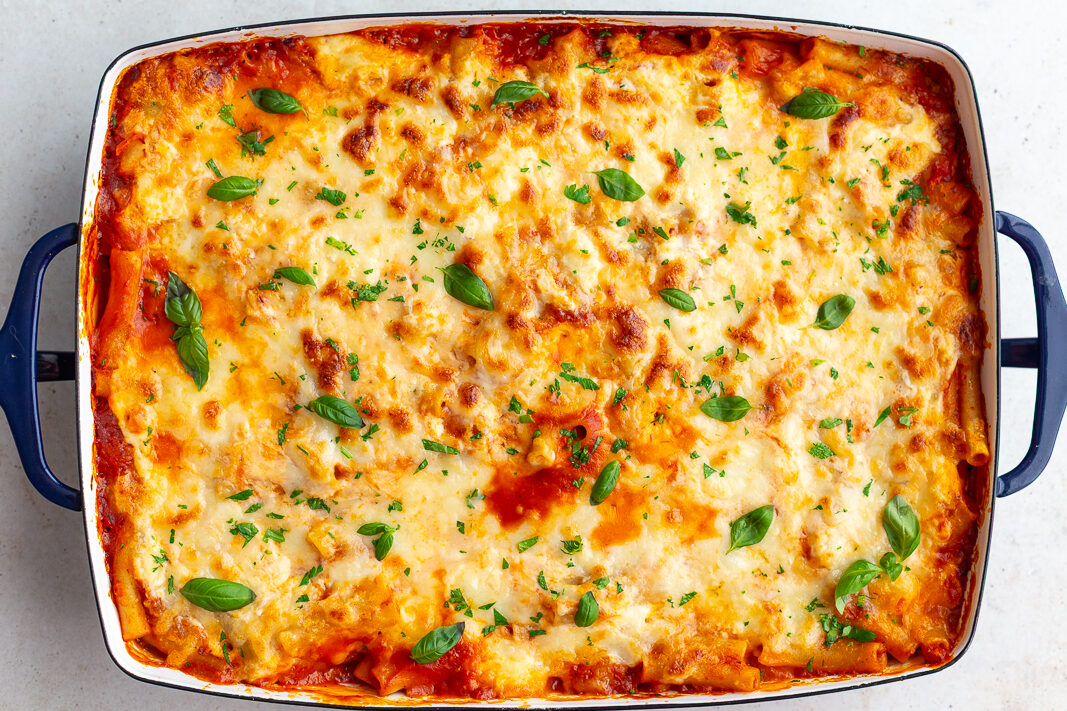 classic baked ziti without meat in a large casserole dish and topped with fresh basil