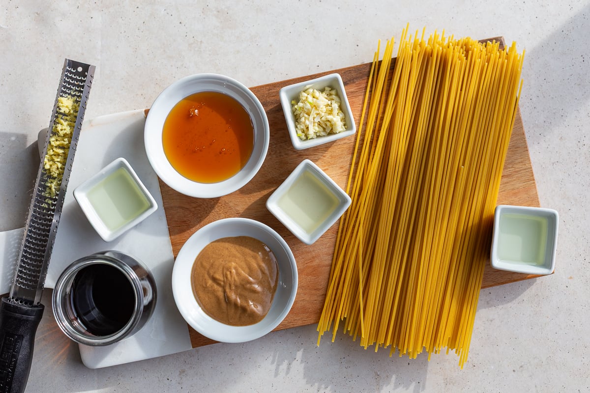 ingredients needed to make peanut noodles including noodles, ginger, garlic, peanut butter and soy sauce