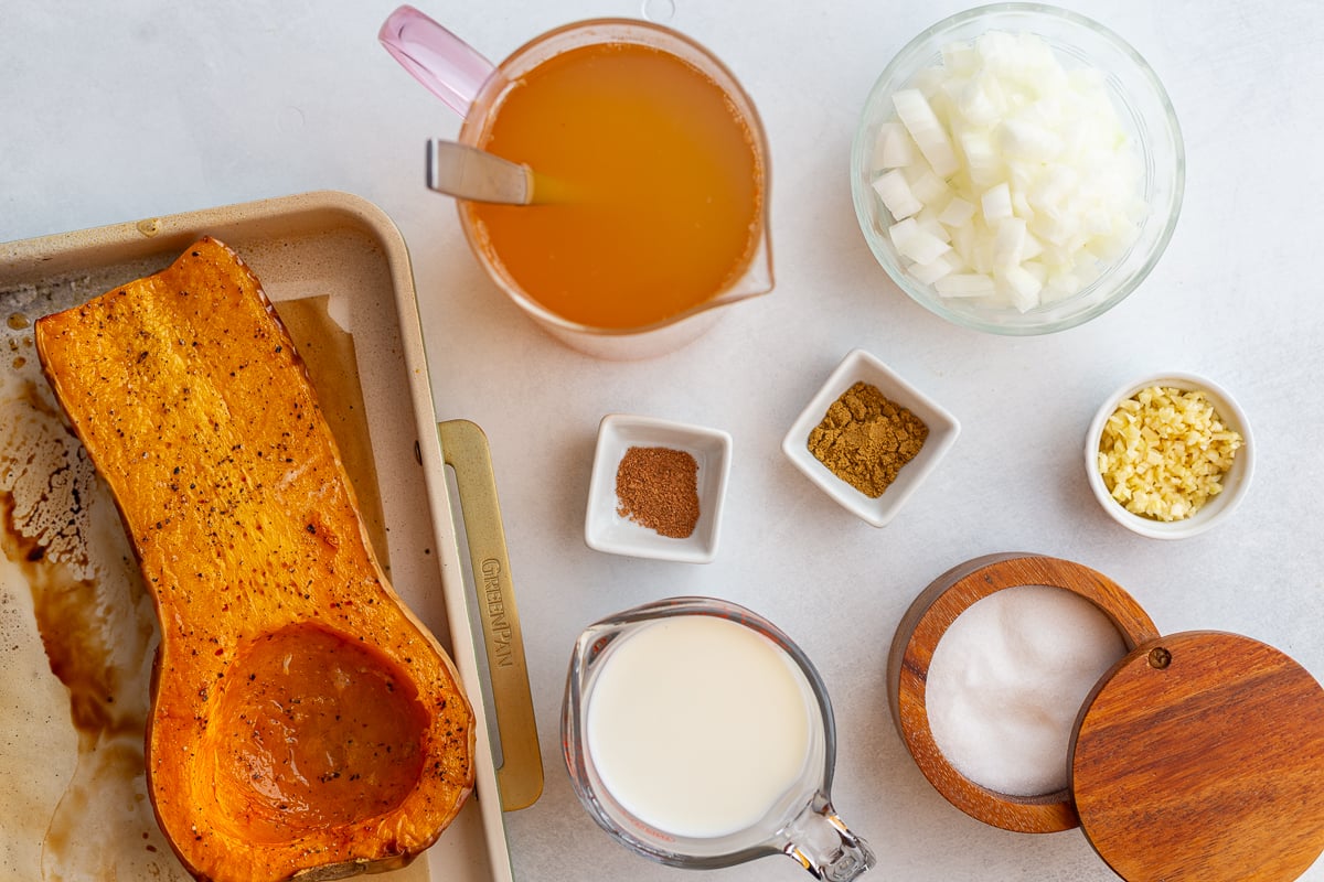 ingredients needed to make Creamy Roasted Butternut Squash Soup including squash, broth, milk, onion, spices, salt, and garlic