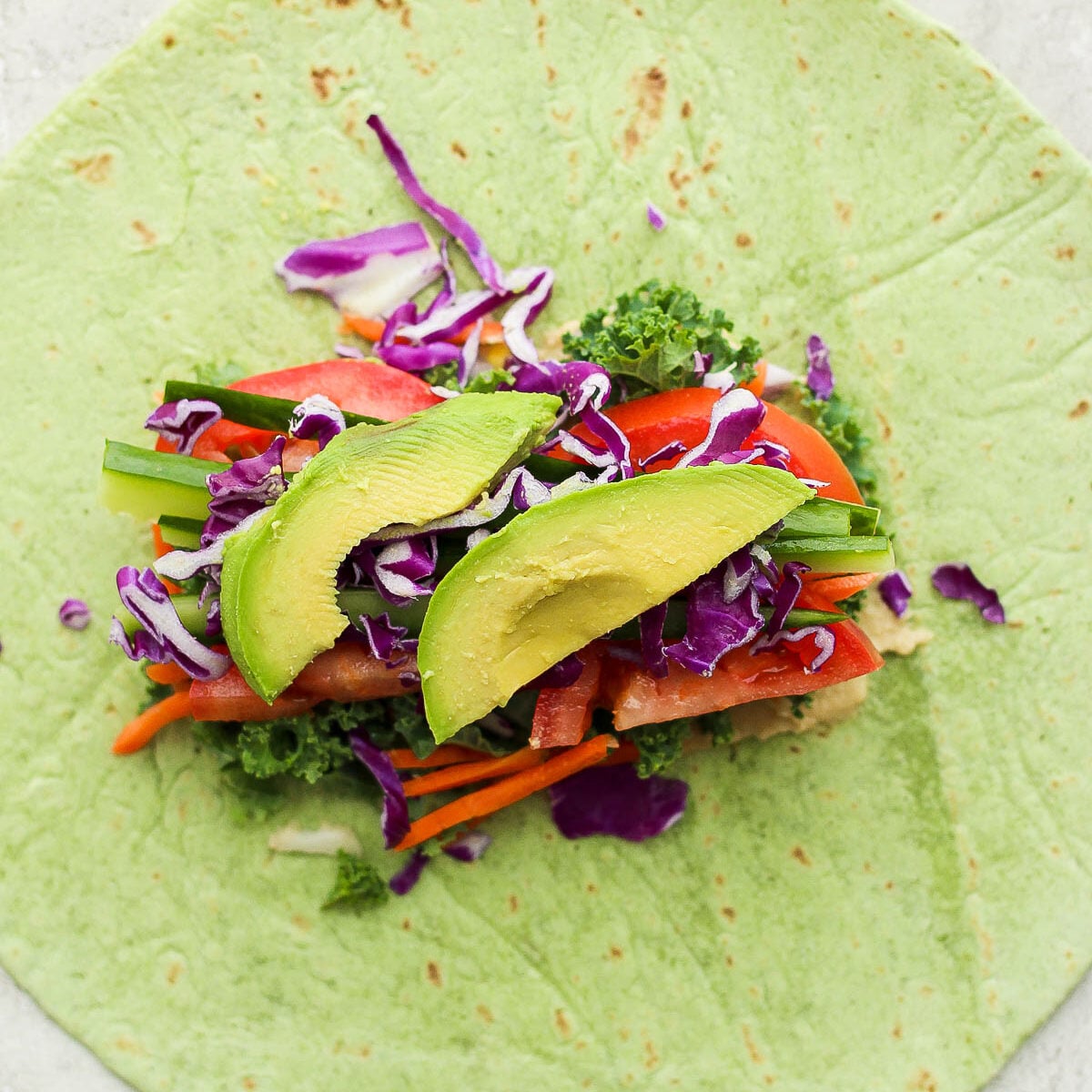 spinach tortilla with fresh veggies in he middle unfolded