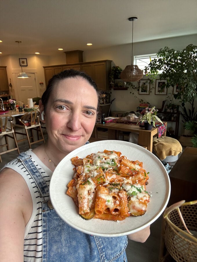 brita britnell holding a plate of cheesy rigatoni