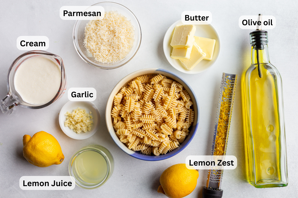 ingredients needed for creamy lemon pasta including pasta, lemon juice and zest, parmesan, heavy cream, garlic and salt