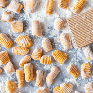homemade sweet potato gnocchi on a large marble board with flour all over