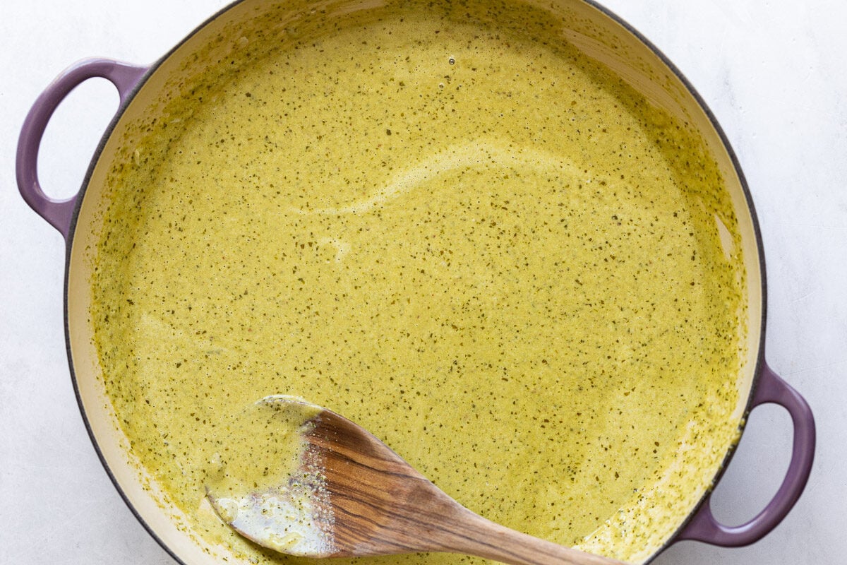 Creamy pesto sauce in a large pot.
