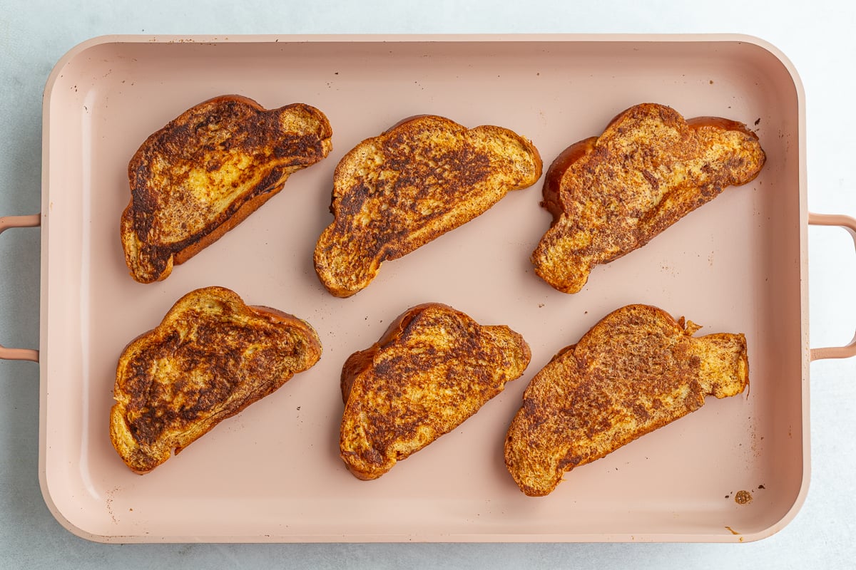 french toast cooking on a light pink griddle