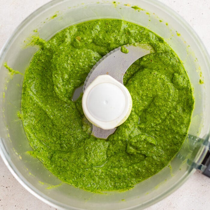 fresh homemade pesto blended up in a food processor base.