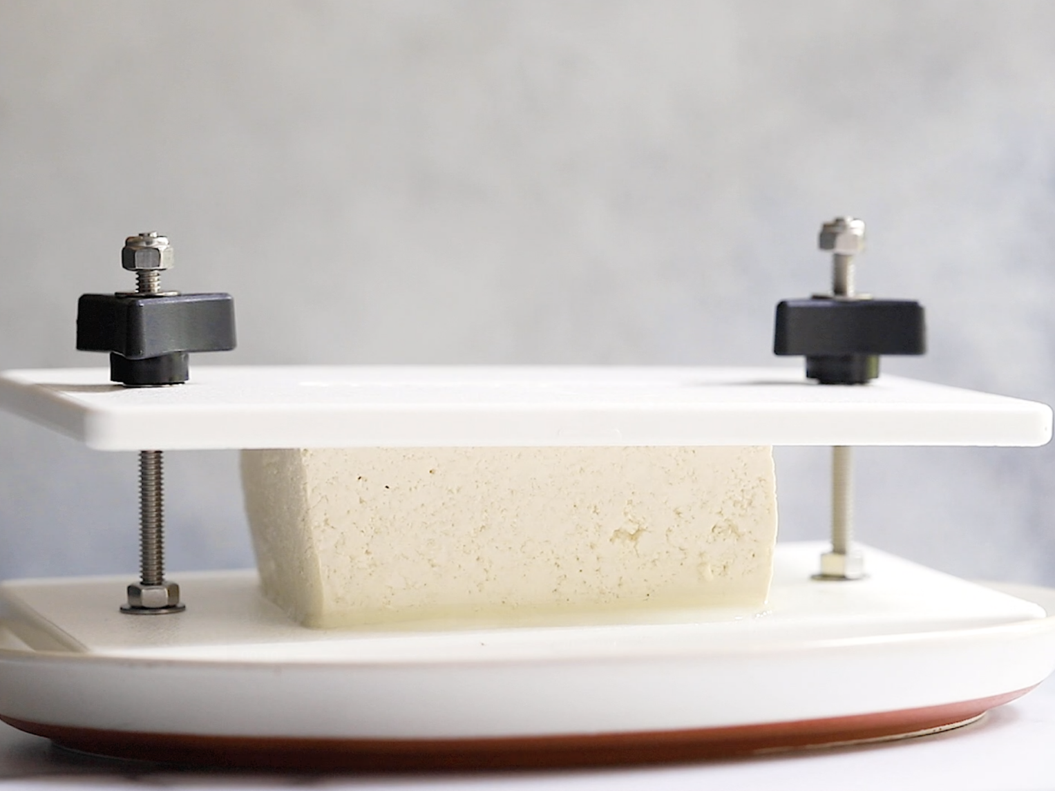 tofu being pressed in a tofu press