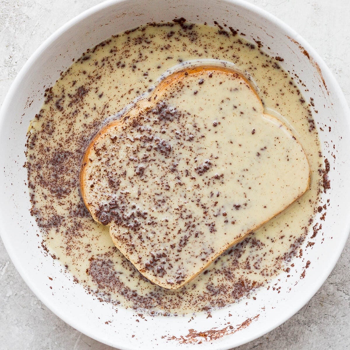 Soaking slice of bread in custard mixture.