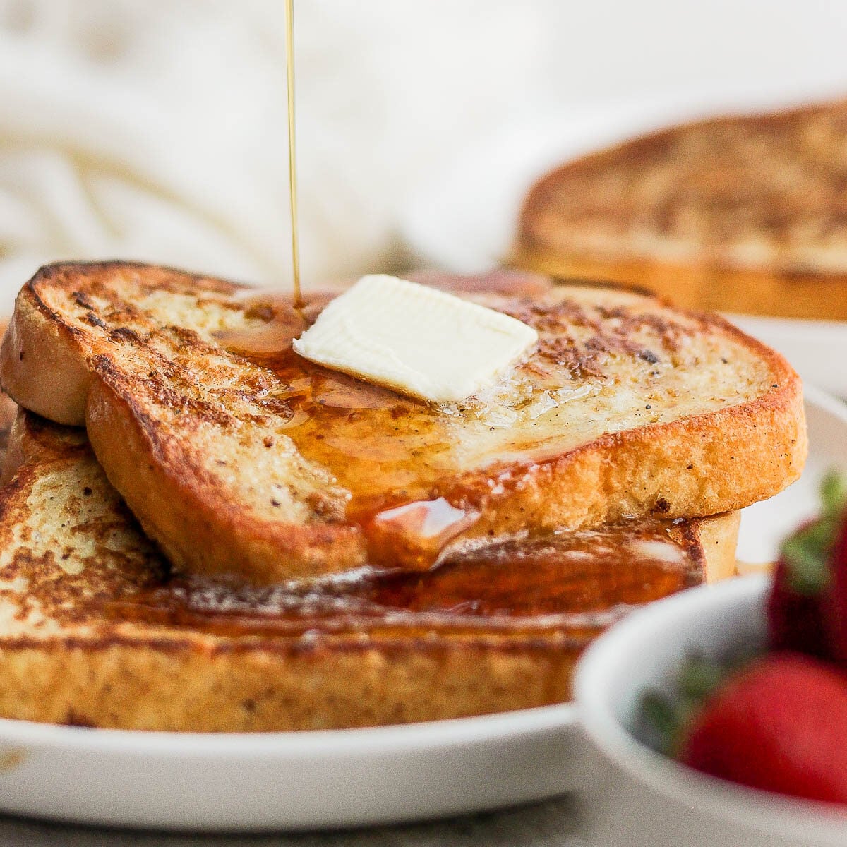 Drizzling syrup over French toast slices.