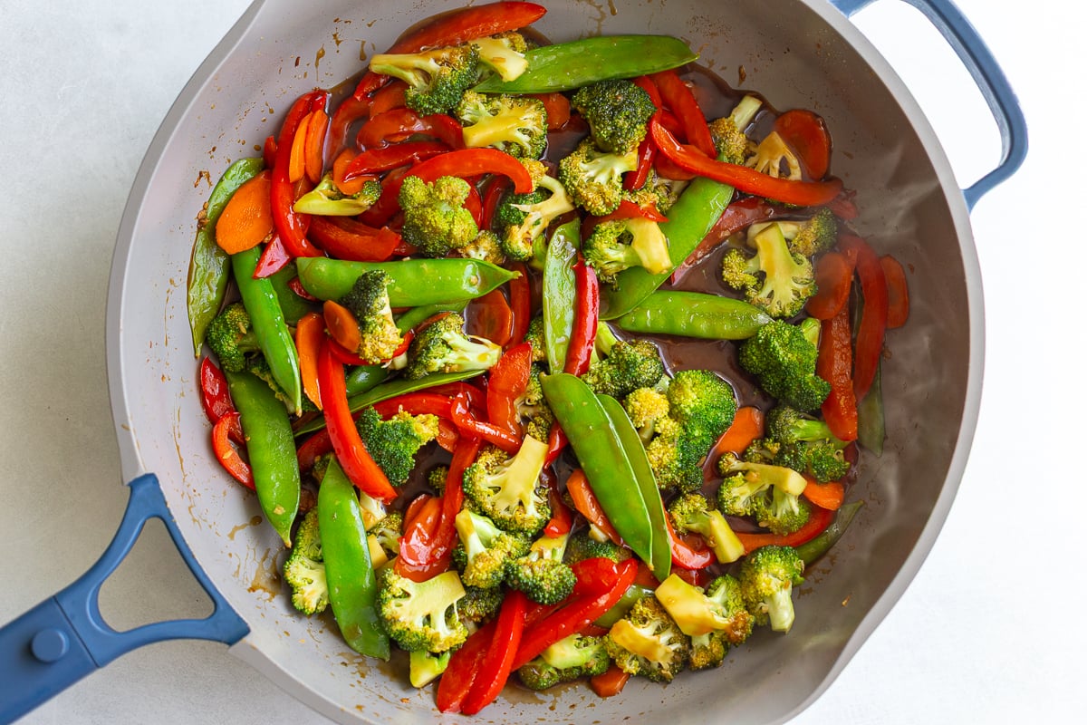 stir fry veggies in a large skillet with sauce