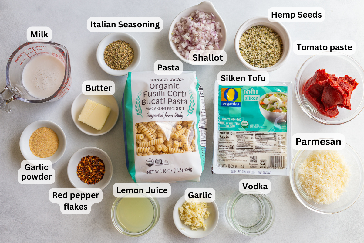 ingredients to make high protein pasta: tomato paste, pasta, silken tofu, seasoning, parmesan, milk, shallot etc