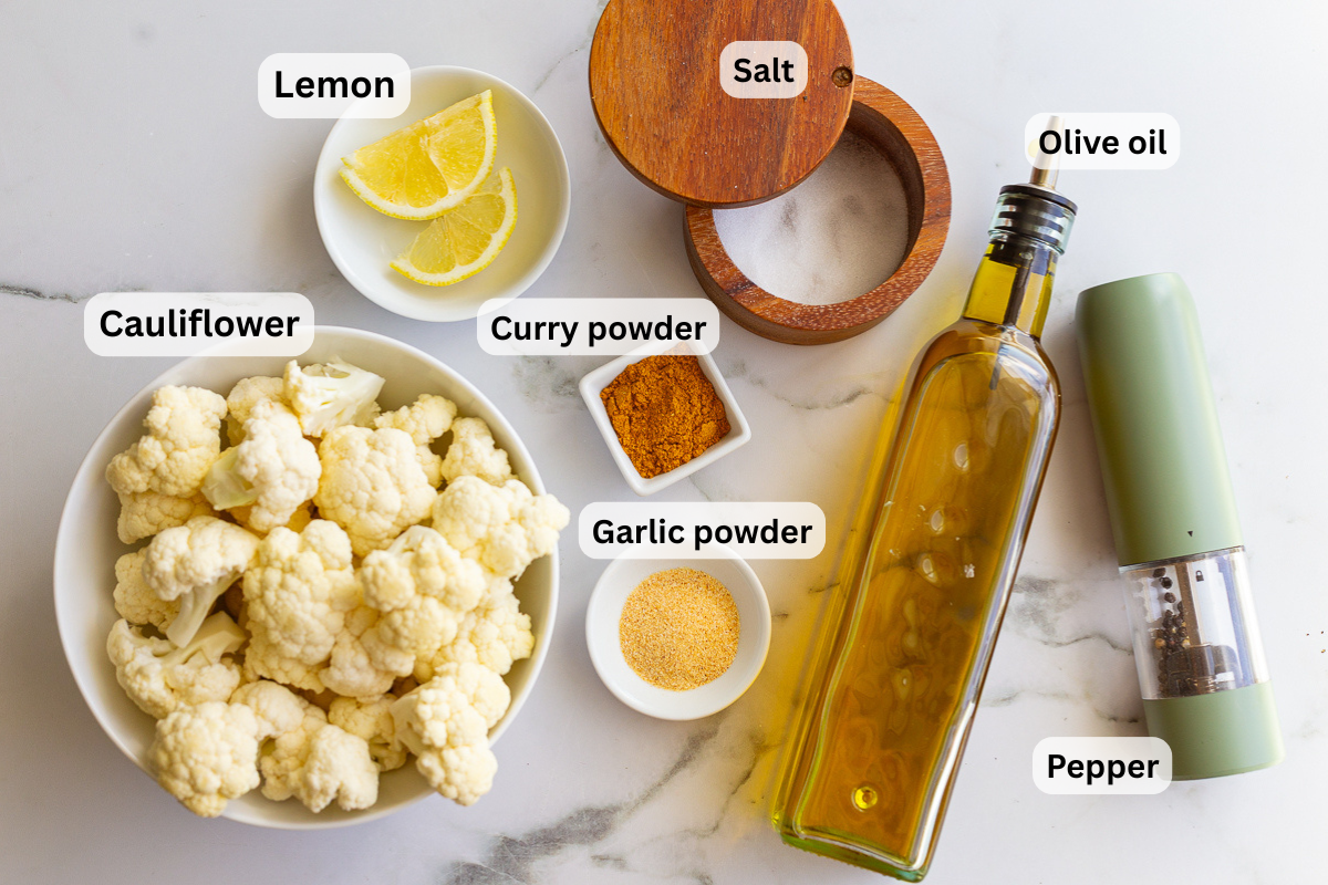 ingredients needed for curry cauliflower including cauliflower, olive oil, salt and pepper, curry powder, garlic powder, lemon