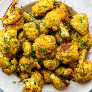 Curried cauliflower served in a white bowl.