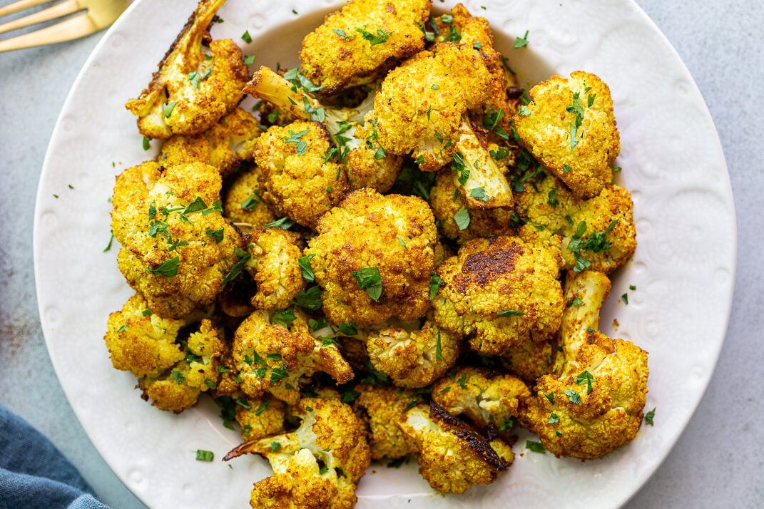 Curried cauliflower served in a white bowl.