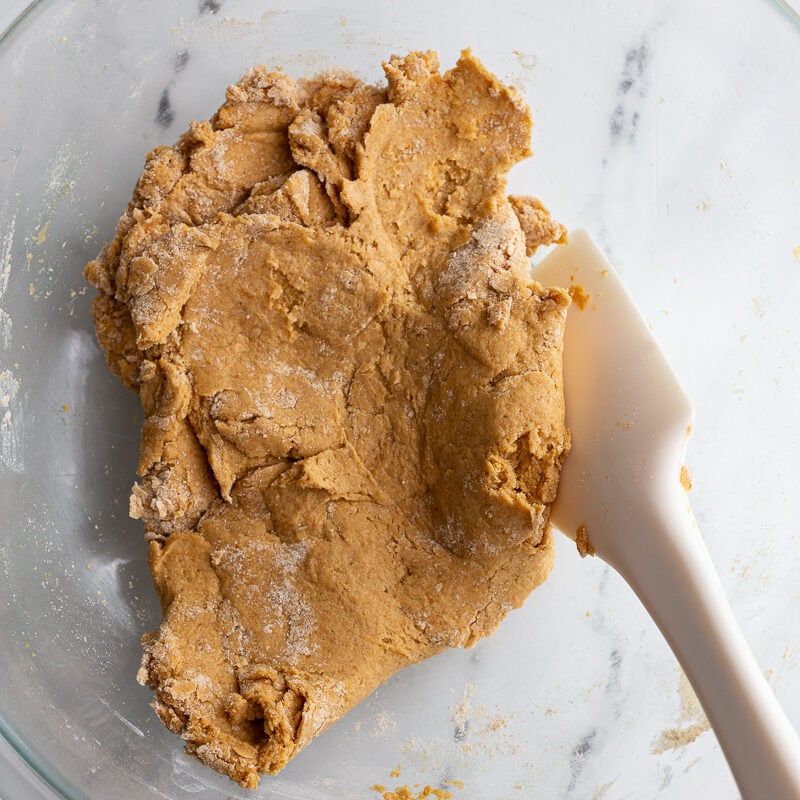 Stirring together pumpkin biscuit batter in a bowl.