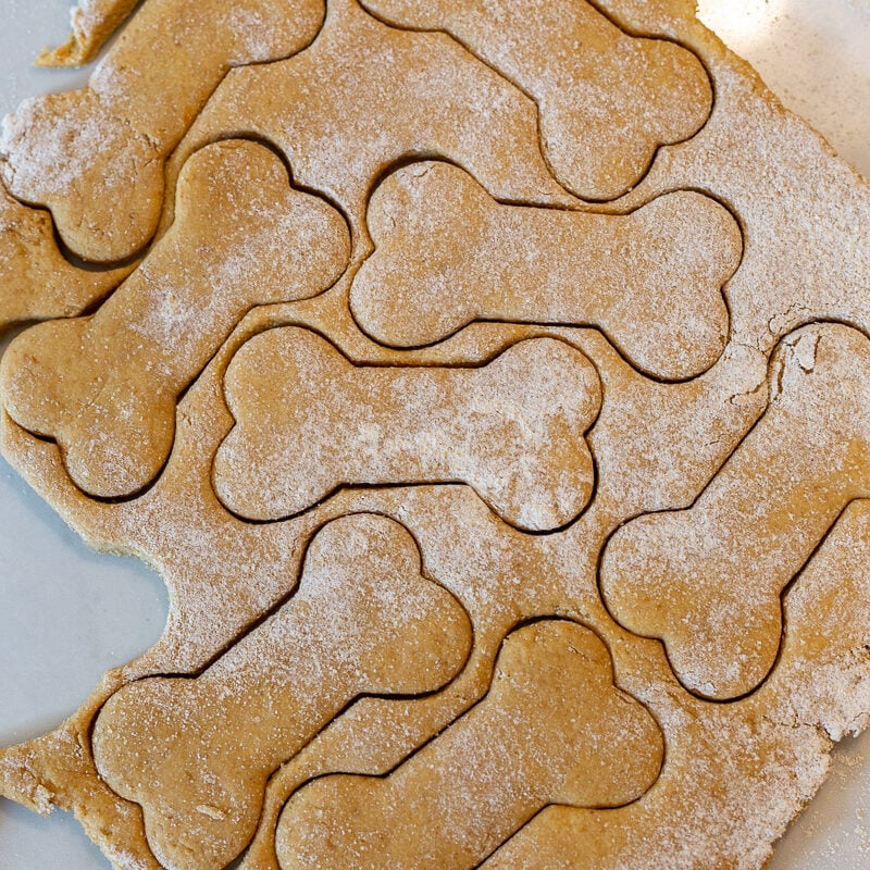 Rolled out dough with dog bone shapes cut out.