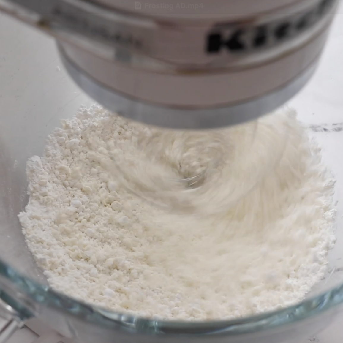 powdered sugar and butter being blended in a food processor